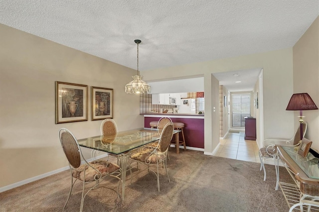 dining area with an inviting chandelier, a textured ceiling, and light colored carpet