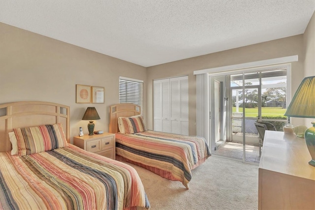 carpeted bedroom featuring access to outside and a textured ceiling