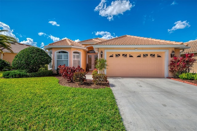 mediterranean / spanish-style house featuring a garage and a front yard