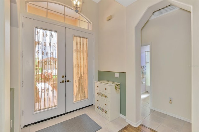 entrance foyer with light tile patterned floors and french doors