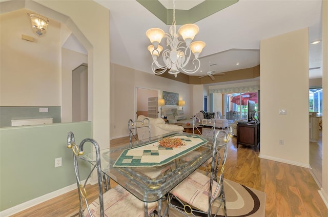 dining area featuring ceiling fan with notable chandelier and light hardwood / wood-style flooring