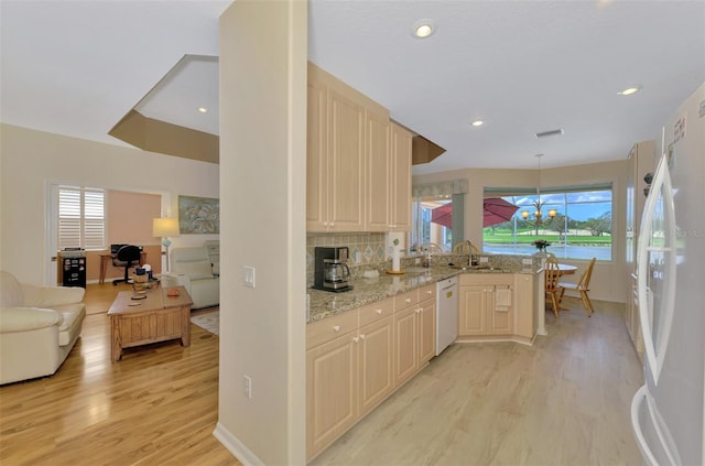 kitchen with sink, white appliances, light hardwood / wood-style flooring, tasteful backsplash, and light stone countertops