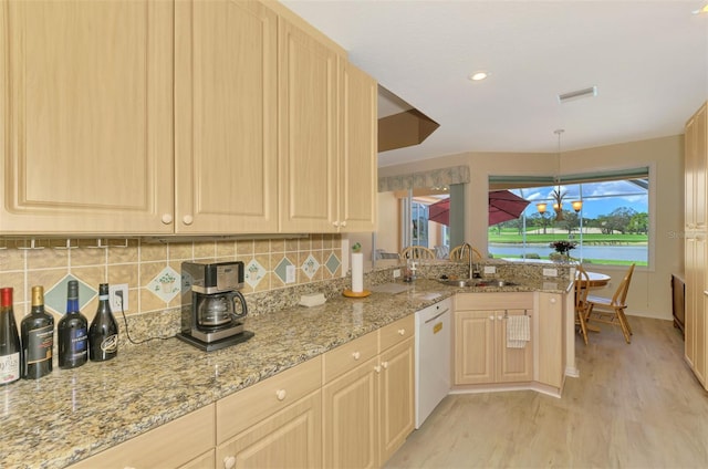 kitchen featuring sink, white dishwasher, and light brown cabinetry