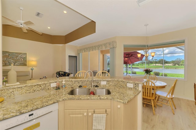 kitchen with sink, light hardwood / wood-style flooring, dishwasher, a water view, and light stone countertops