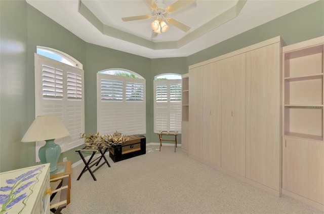 sitting room featuring light colored carpet, a raised ceiling, and ceiling fan