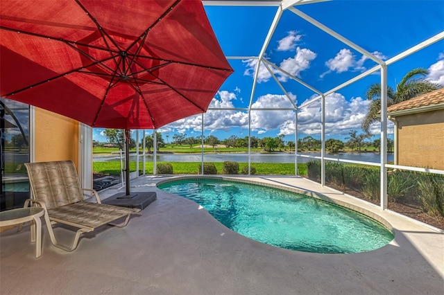 view of pool with a patio, glass enclosure, and a water view