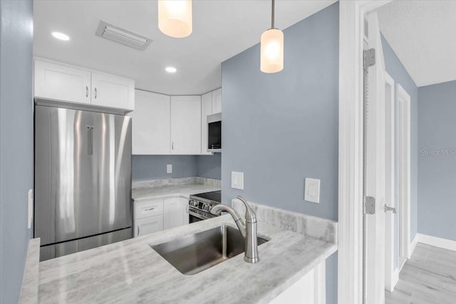 902 Gibbs Rd Unit 181, Venice, FL 34285 - kitchen with appliances with stainless steel finishes, white cabinets, decorative light fixtures, and recessed lighting