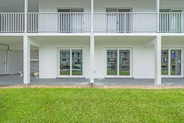 902 Gibbs Rd Unit 181, Venice, FL 34285 - back of house featuring stucco siding, a lawn, and a balcony