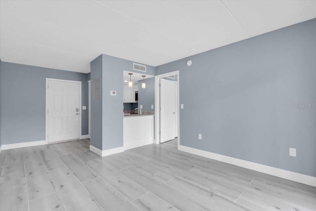 902 Gibbs Rd Unit 181, Venice, FL 34285 - unfurnished living room with baseboards and light wood-style floors