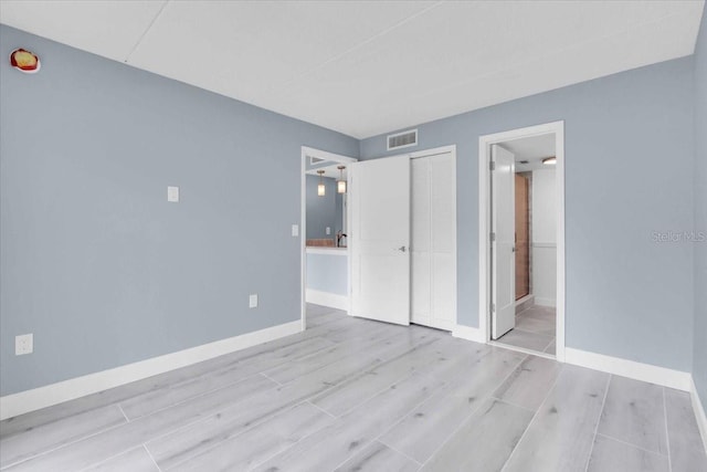 902 Gibbs Rd Unit 181, Venice, FL 34285 - unfurnished bedroom with wood finished floors, a closet, and ensuite bath