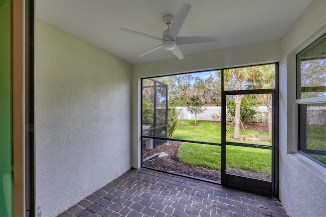 unfurnished sunroom with ceiling fan