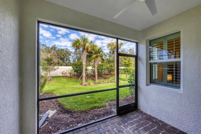 unfurnished sunroom with ceiling fan