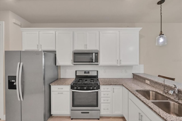 kitchen with sink, white cabinetry, decorative light fixtures, stainless steel appliances, and decorative backsplash