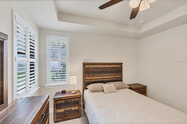 bedroom featuring ceiling fan and a raised ceiling