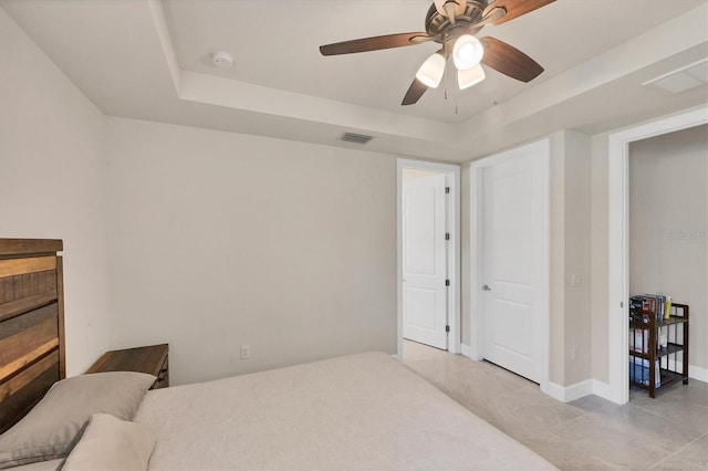 bedroom featuring ceiling fan and a tray ceiling