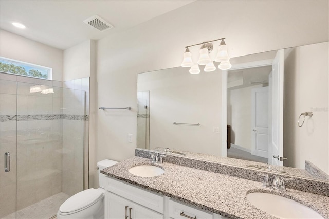 bathroom with vanity, toilet, and a shower with door