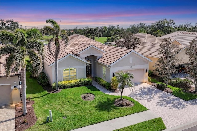 ranch-style house featuring a garage and a yard