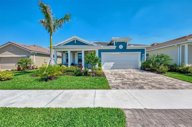 view of front of property with decorative driveway, an attached garage, and a front yard