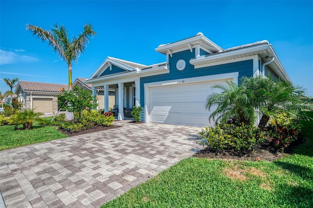 view of front of home with a garage and decorative driveway