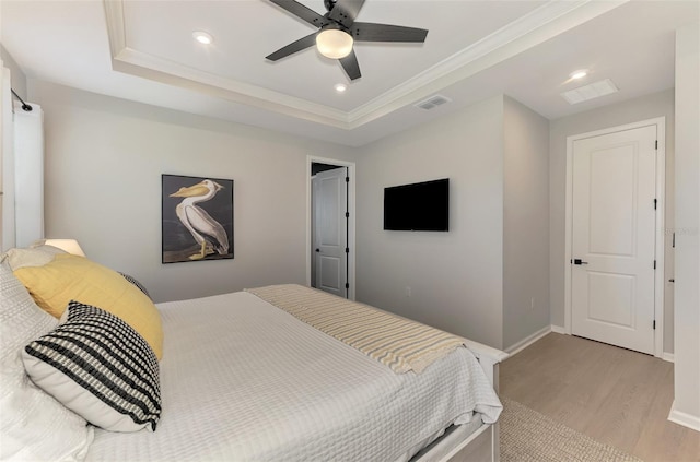 bedroom featuring recessed lighting, visible vents, baseboards, light wood-style floors, and a raised ceiling