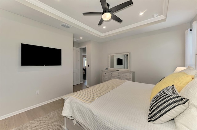 bedroom featuring baseboards, visible vents, a raised ceiling, wood finished floors, and recessed lighting