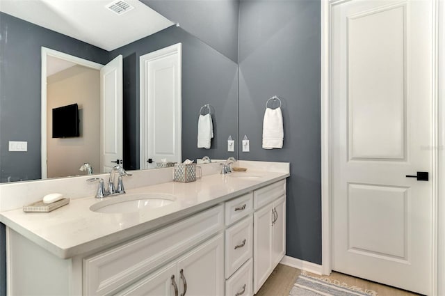 full bathroom featuring visible vents, a sink, baseboards, and double vanity