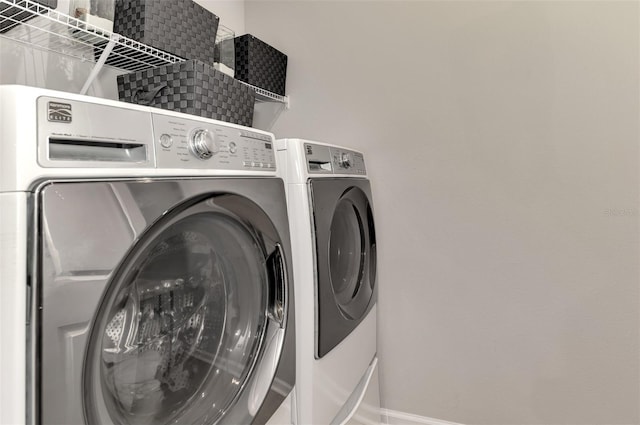 laundry area featuring laundry area, washer and clothes dryer, and baseboards