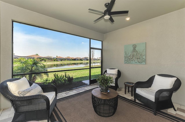 sunroom / solarium featuring a ceiling fan and a water view