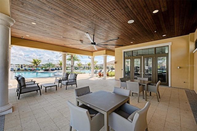 view of patio / terrace with a community pool, a ceiling fan, and outdoor dining space