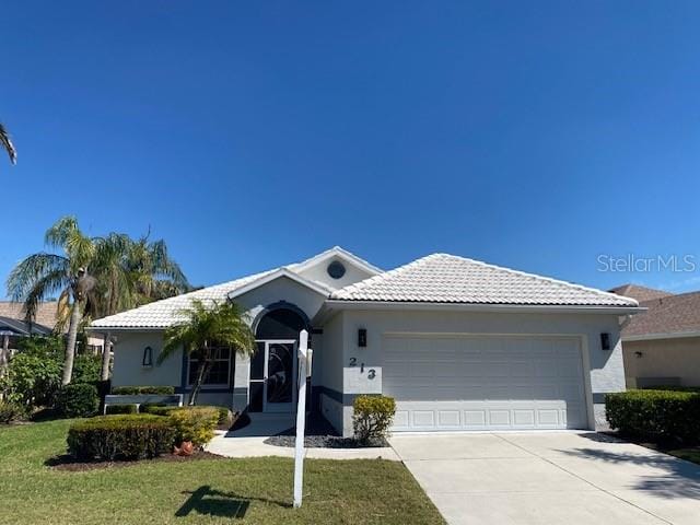 single story home with stucco siding, concrete driveway, a front lawn, and a tiled roof