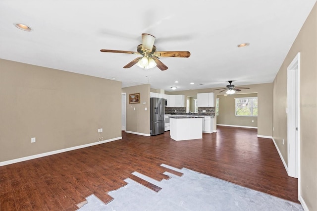 unfurnished living room featuring dark wood-type flooring, recessed lighting, a ceiling fan, and baseboards