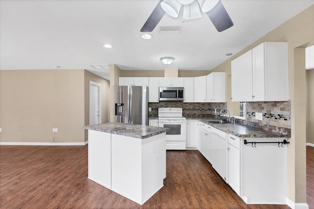 kitchen featuring visible vents, white cabinets, a center island, stainless steel appliances, and a sink