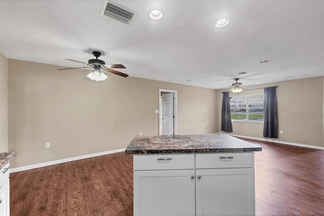 kitchen featuring visible vents, white cabinetry, open floor plan, baseboards, and dark wood-style floors