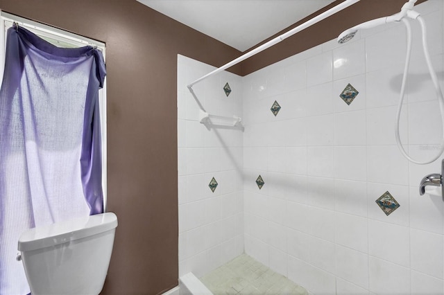 full bathroom featuring toilet and tiled shower