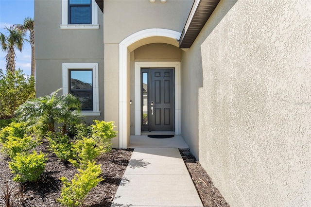 entrance to property featuring stucco siding