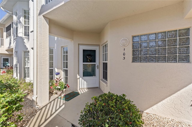 view of exterior entry featuring a patio area and stucco siding