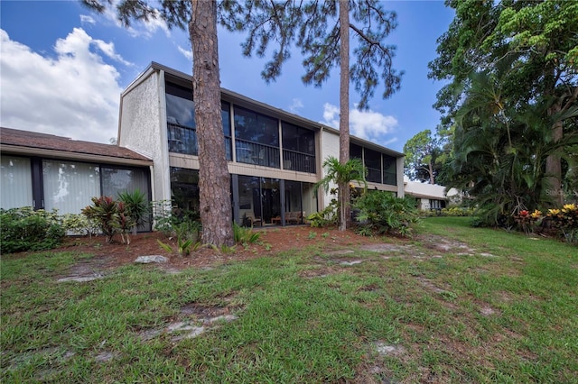 back of house featuring a yard and a sunroom