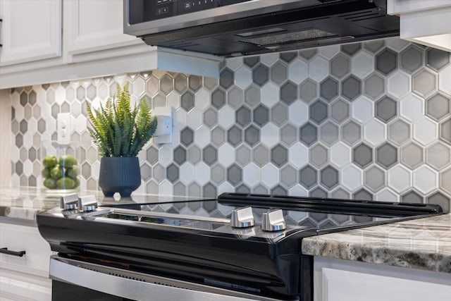 kitchen with decorative backsplash, white cabinets, light stone countertops, and stainless steel appliances