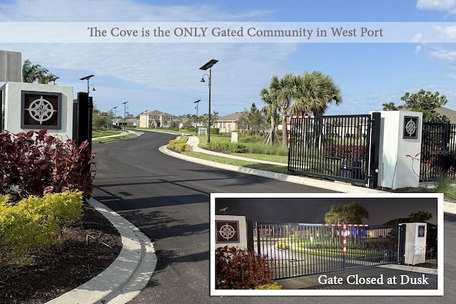 view of road with sidewalks, curbs, a gated entry, and street lighting