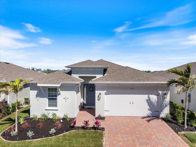 view of front of house with stucco siding, decorative driveway, a garage, and roof with shingles