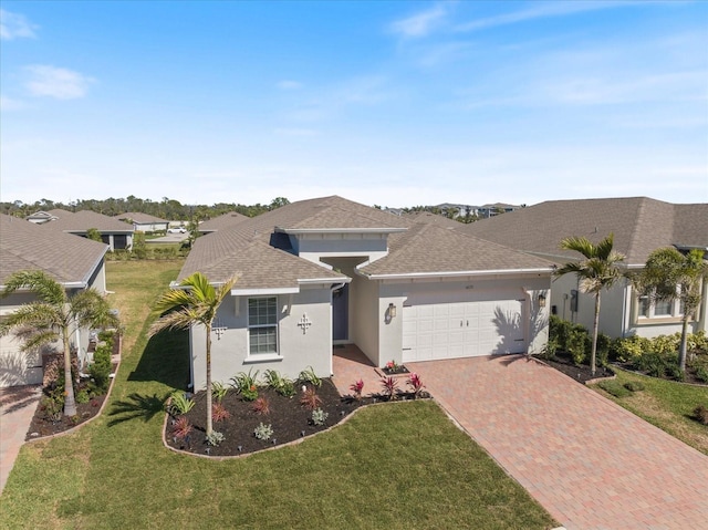 view of front of home featuring a shingled roof, a front lawn, stucco siding, decorative driveway, and a garage