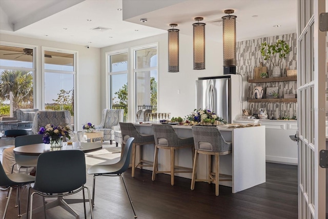 kitchen featuring a kitchen bar, dark wood-type flooring, open shelves, and freestanding refrigerator