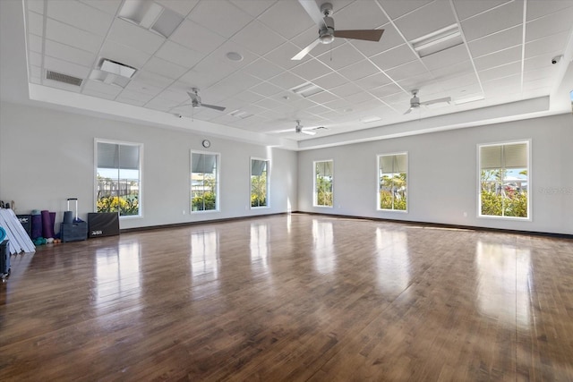 interior space featuring visible vents, a ceiling fan, wood finished floors, baseboards, and a paneled ceiling