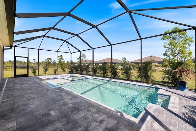 view of pool with glass enclosure, a pool with connected hot tub, and a patio