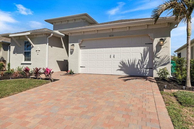 view of front of house featuring a garage, decorative driveway, and stucco siding