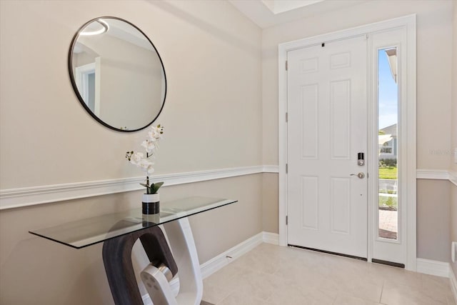 foyer entrance with light tile patterned floors and baseboards