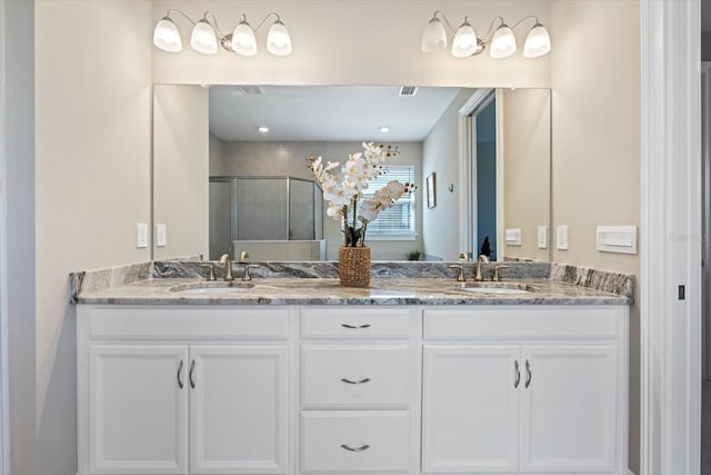 full bathroom with a sink, visible vents, a stall shower, and double vanity