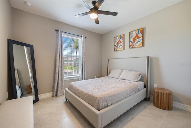 bedroom with light tile patterned floors, a ceiling fan, and baseboards