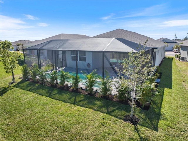 rear view of house featuring a lanai, an outdoor pool, and a yard