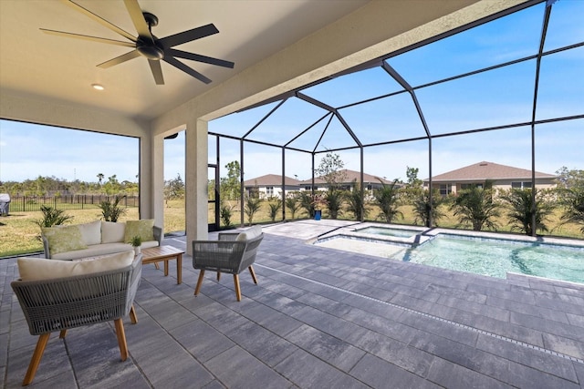 view of swimming pool with a pool with connected hot tub, an outdoor living space, glass enclosure, ceiling fan, and a patio area